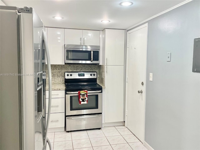 kitchen featuring backsplash, white cabinets, light tile patterned floors, and stainless steel appliances