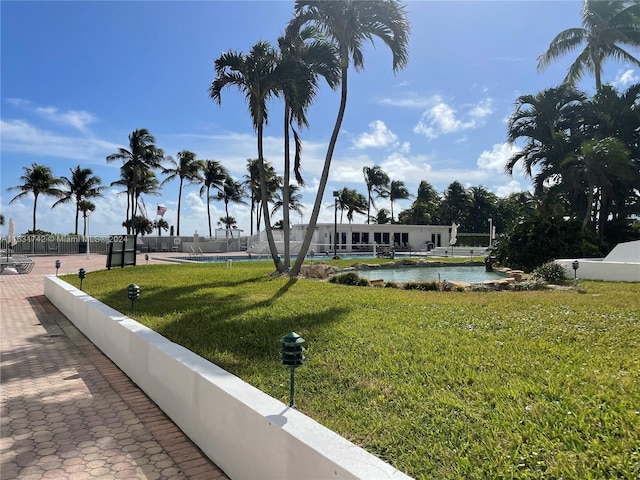 view of home's community featuring a lawn and a pool