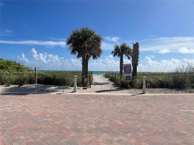 view of patio with a water view and volleyball court