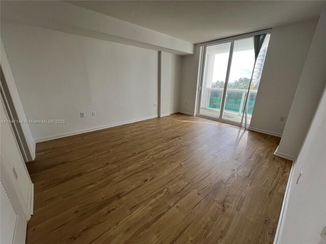 10275 Collins Ave Unit 415, Bal Harbour, FL 33154 - unfurnished room with wood finished floors, baseboards, and floor to ceiling windows