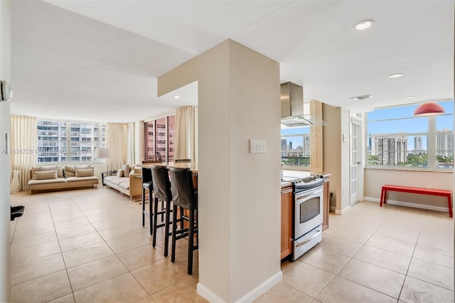 18041 Biscayne Blvd Unit 1404, Aventura, FL 33160 - kitchen with electric stove, wall chimney range hood, light tile patterned flooring, a view of city, and recessed lighting