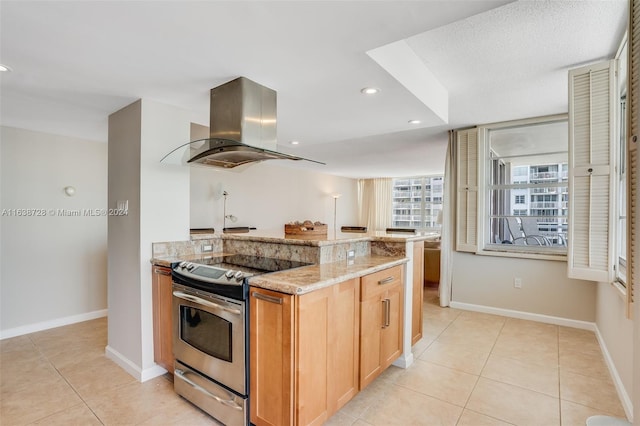 kitchen featuring light tile patterned floors, island range hood, light stone counters, and stainless steel electric range