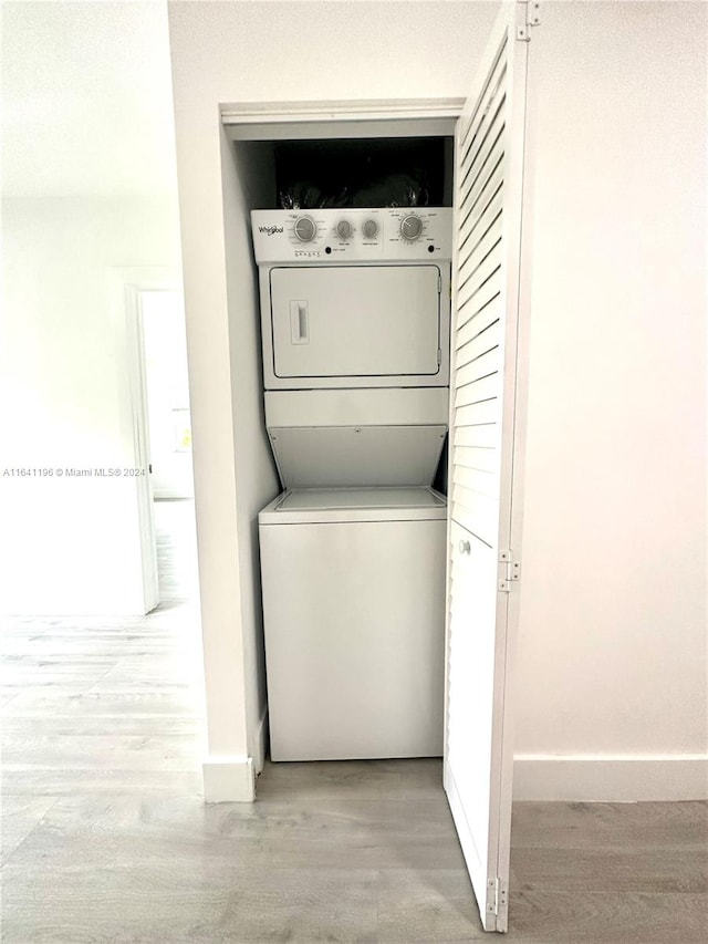 clothes washing area with stacked washer and dryer