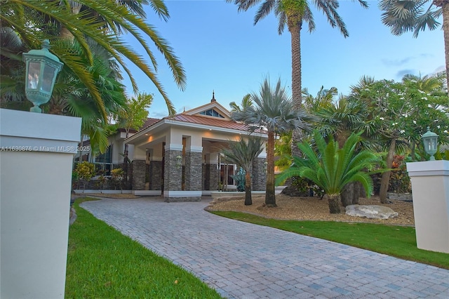 view of front of home with a standing seam roof, stucco siding, stone siding, and metal roof