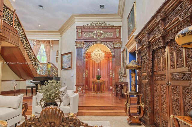 living room featuring decorative columns, high vaulted ceiling, and hardwood / wood-style flooring