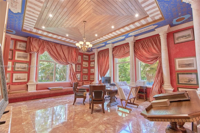 interior space with decorative columns, a raised ceiling, wooden ceiling, and an inviting chandelier