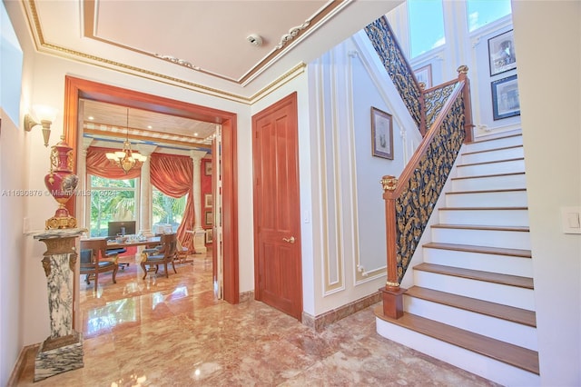 interior space featuring crown molding, a tray ceiling, tile patterned flooring, and an inviting chandelier