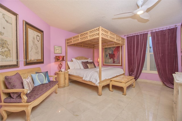 tiled bedroom with ceiling fan and a textured ceiling