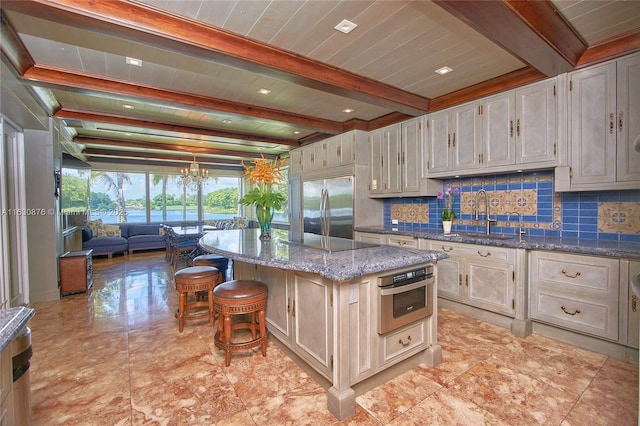 2941 Paddock Ln, Weston, FL 33331 - kitchen featuring a sink, appliances with stainless steel finishes, decorative backsplash, a kitchen island, and dark stone counters