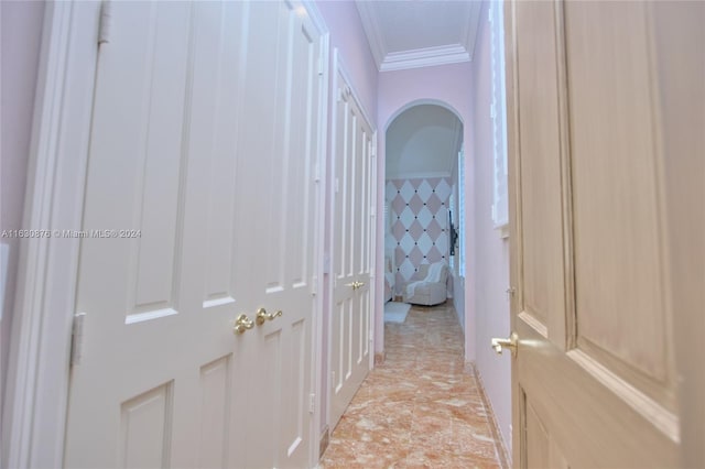 hall with light tile patterned flooring and ornamental molding