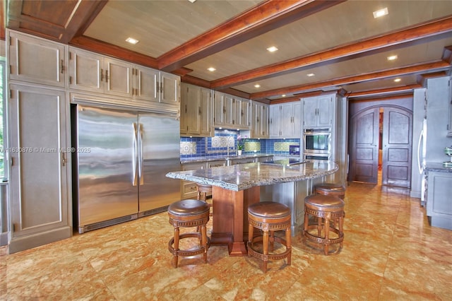 2941 Paddock Ln, Weston, FL 33331 - kitchen featuring stainless steel appliances, beamed ceiling, backsplash, stone countertops, and a kitchen breakfast bar