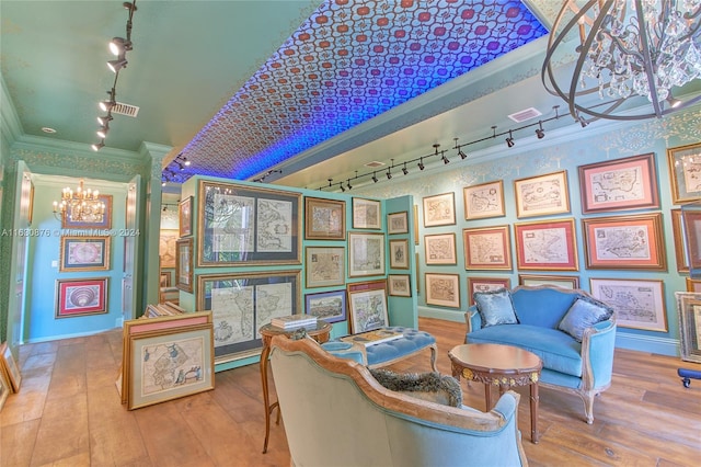 interior space featuring ornamental molding, track lighting, and a chandelier