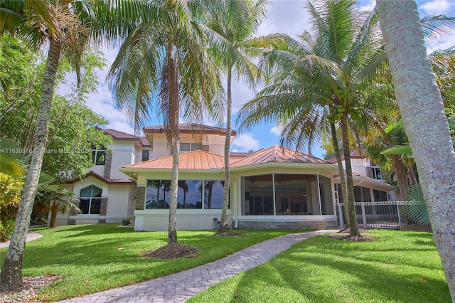 back of house featuring a lawn and a sunroom