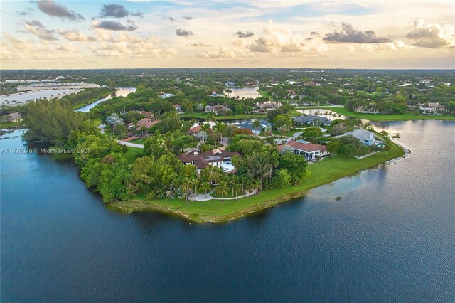 aerial view at dusk featuring a water view