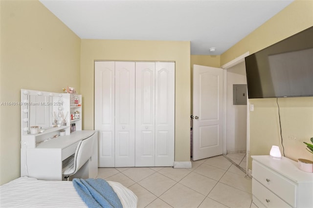 tiled bedroom with electric panel and a closet