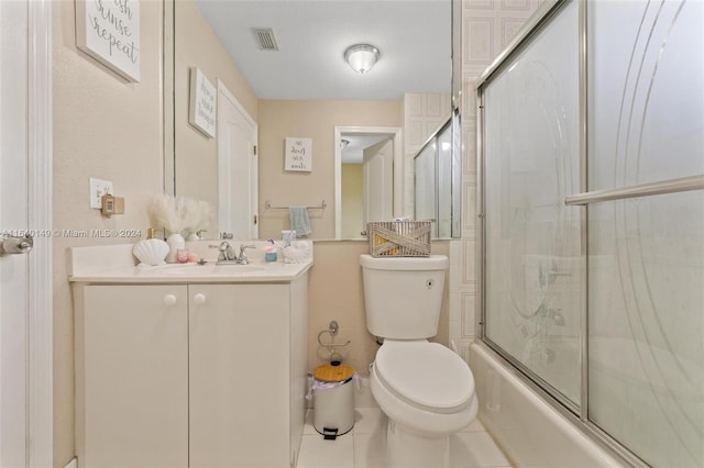 full bathroom featuring enclosed tub / shower combo, vanity, toilet, and tile patterned floors