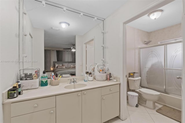 full bathroom with vanity, ceiling fan, bath / shower combo with glass door, toilet, and tile patterned floors