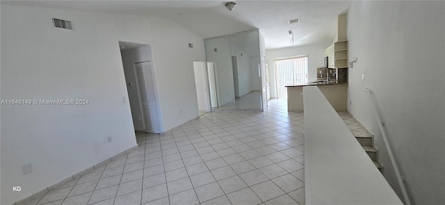 tiled spare room with lofted ceiling