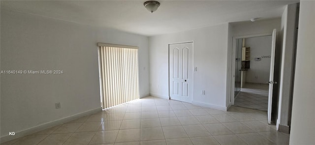 unfurnished bedroom with light tile patterned flooring and a closet