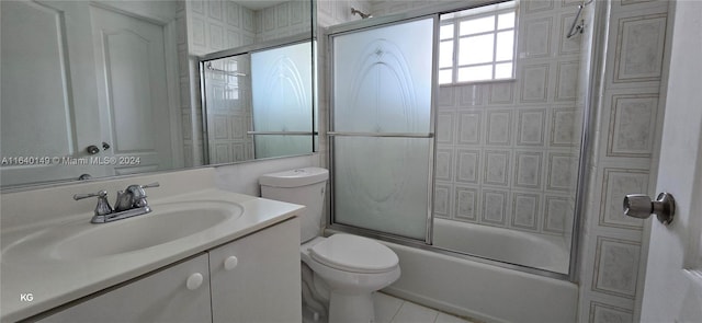 full bathroom featuring bath / shower combo with glass door, vanity, tile patterned flooring, and toilet