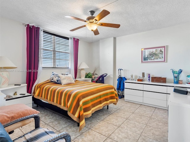 tiled bedroom with ceiling fan and a textured ceiling