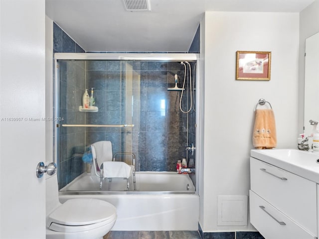 full bathroom featuring enclosed tub / shower combo, vanity, tile patterned flooring, and toilet