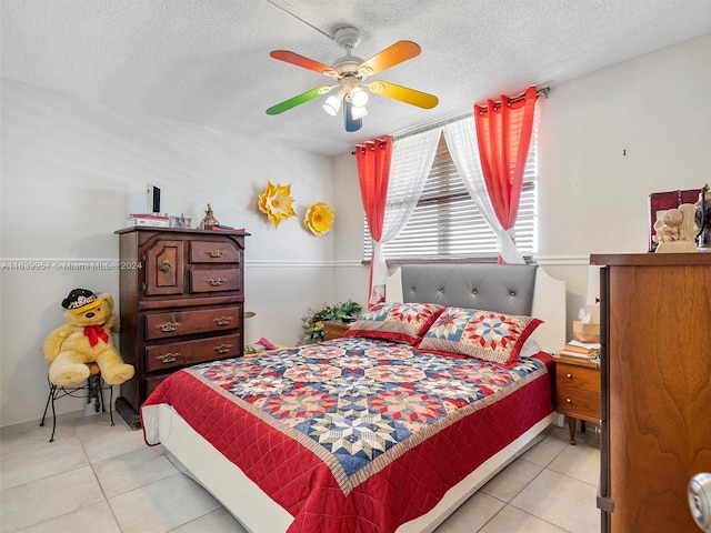 bedroom with ceiling fan, a textured ceiling, and light tile patterned floors