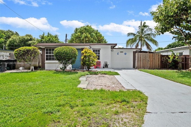 ranch-style house featuring driveway, fence, a front lawn, and stucco siding