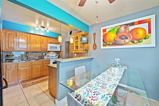 kitchen featuring white appliances, hanging light fixtures, decorative backsplash, ceiling fan, and sink