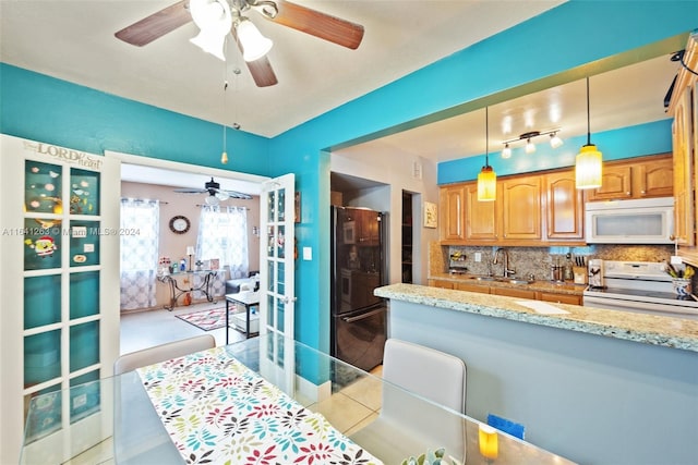 kitchen with pendant lighting, white appliances, ceiling fan, sink, and tasteful backsplash