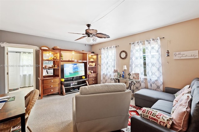 carpeted living area featuring a ceiling fan