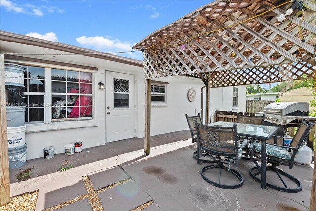 view of patio with a pergola and a grill