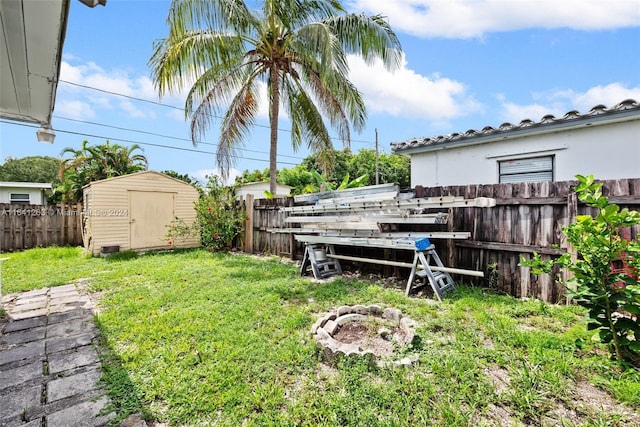 view of yard with an outbuilding, a storage unit, and a fenced backyard