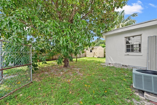 view of yard featuring central AC, a shed, an outdoor structure, and a fenced backyard