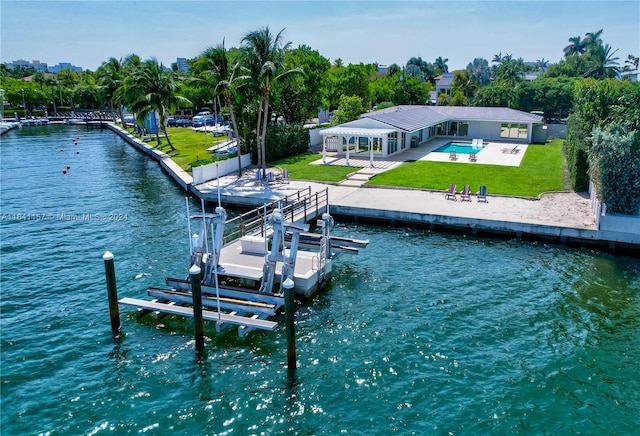 view of dock with a water view, a pool, a patio area, and a lawn