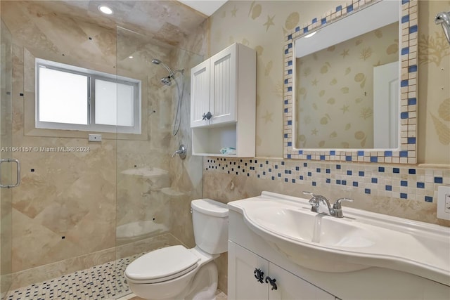 bathroom with toilet, vanity, tile walls, and tiled shower