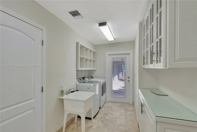 laundry room featuring cabinets and washer and dryer