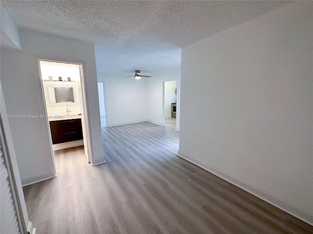 hall with hardwood / wood-style floors and a textured ceiling