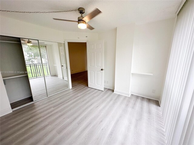 unfurnished bedroom with a closet, ceiling fan, a textured ceiling, and light wood-type flooring