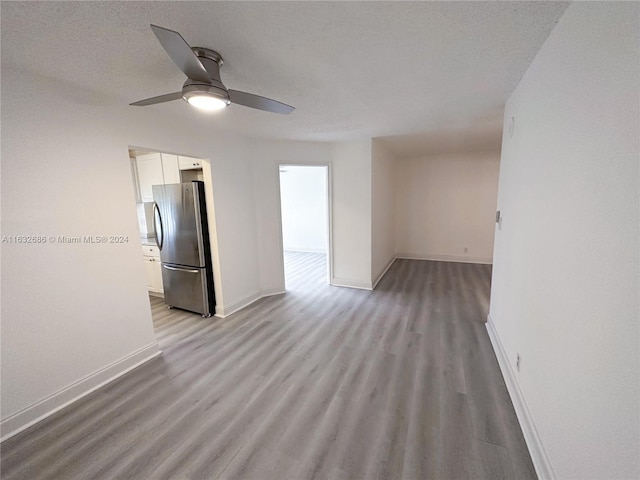 unfurnished room featuring a textured ceiling, light wood-type flooring, and ceiling fan