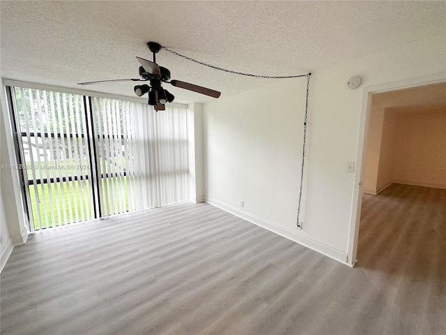 unfurnished room with a textured ceiling, light wood-type flooring, and a wealth of natural light