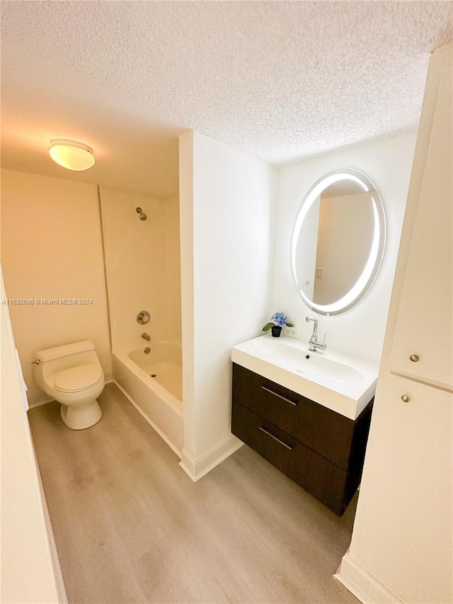 bathroom with vanity, a textured ceiling, and toilet