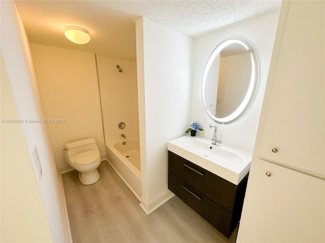 full bathroom featuring shower / bathing tub combination, hardwood / wood-style floors, a textured ceiling, toilet, and vanity