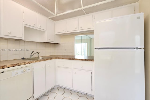 kitchen with decorative backsplash, white cabinetry, light tile patterned floors, white appliances, and sink