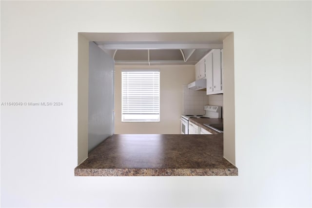 kitchen featuring backsplash, white cabinetry, and white electric range