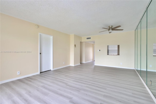 empty room with a textured ceiling, hardwood / wood-style floors, and ceiling fan