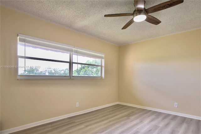 unfurnished room with ceiling fan, light hardwood / wood-style flooring, and a textured ceiling