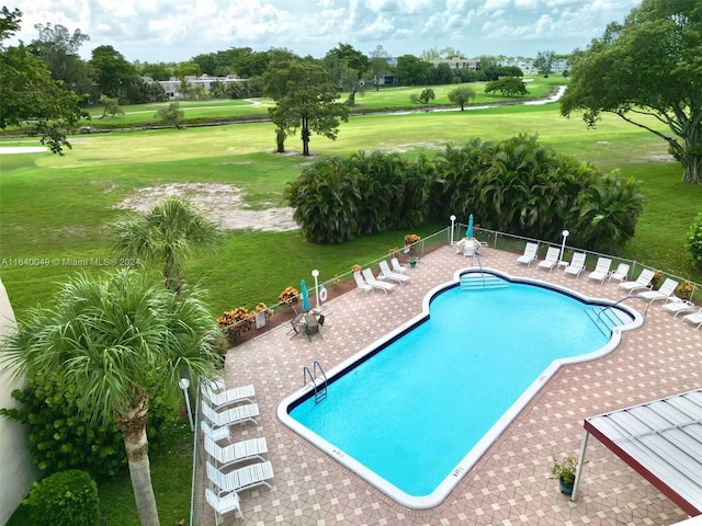 view of pool featuring a lawn and a patio