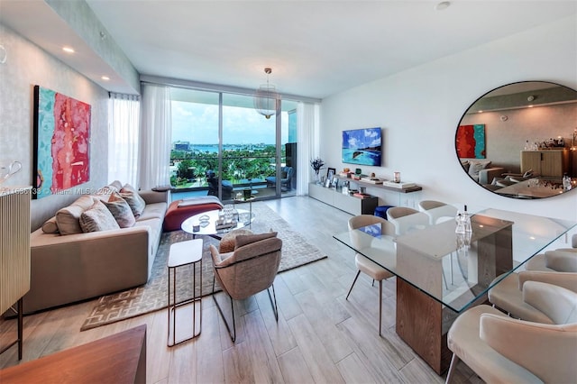 living room featuring a wall of windows and light hardwood / wood-style floors