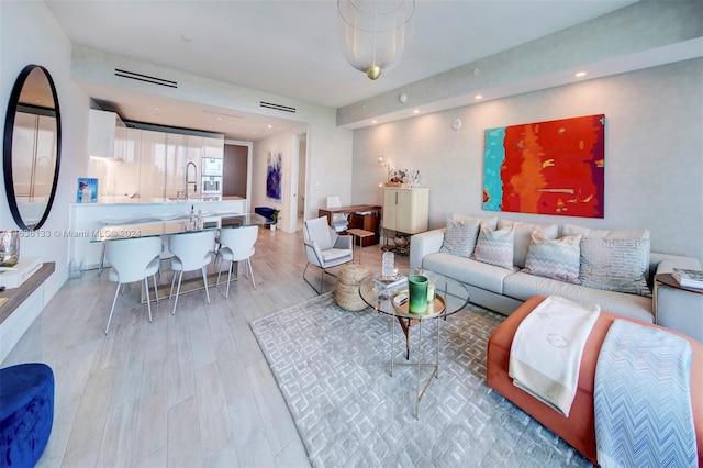 living room featuring sink and light wood-type flooring